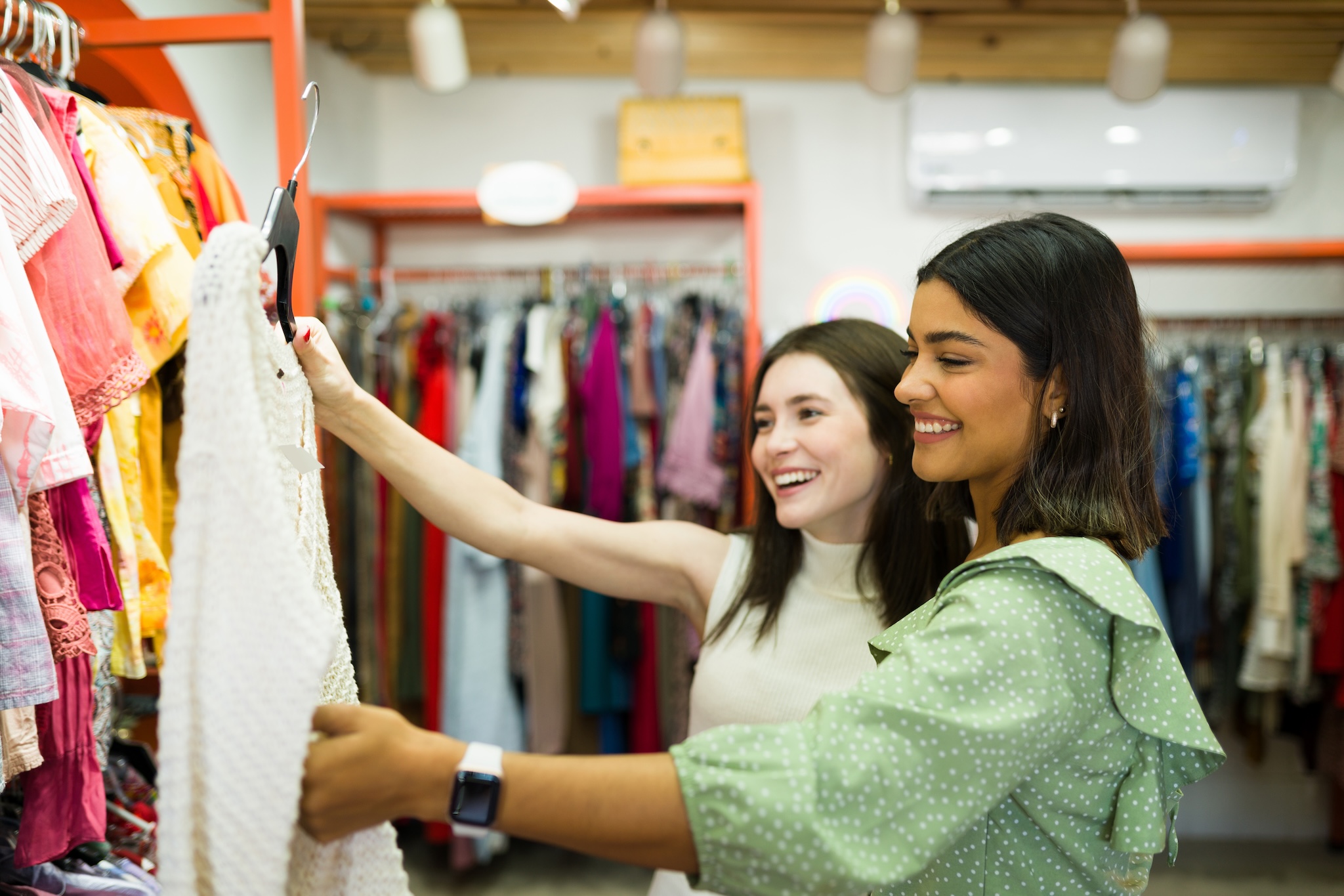 Two women shopping for clothing at WINS Thrift Store in Calgary, Alta.